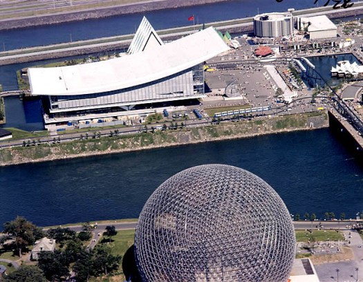The Soviet pavilion with its sloping roof and faceless exterior sits across the water from the US geodesic dome.